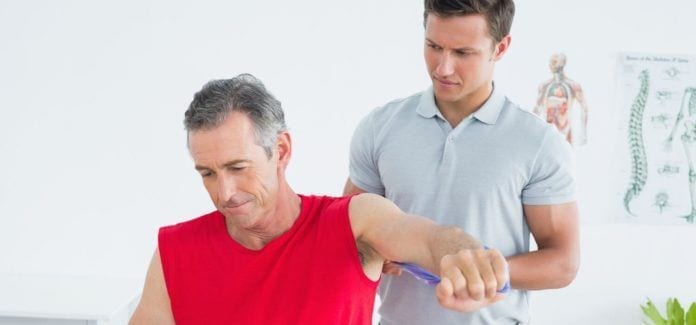 NJ Health-Male physiotherapist examining mans arm