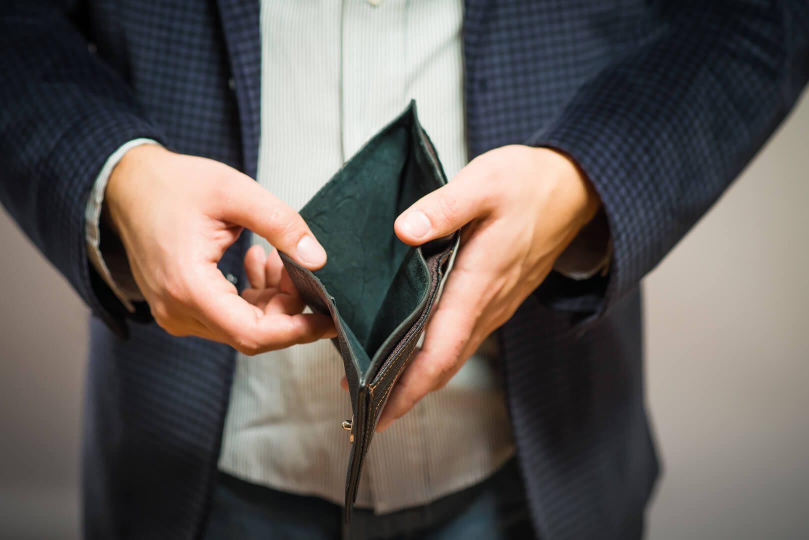 Bankruptcy - Business Person holding an empty wallet in debt