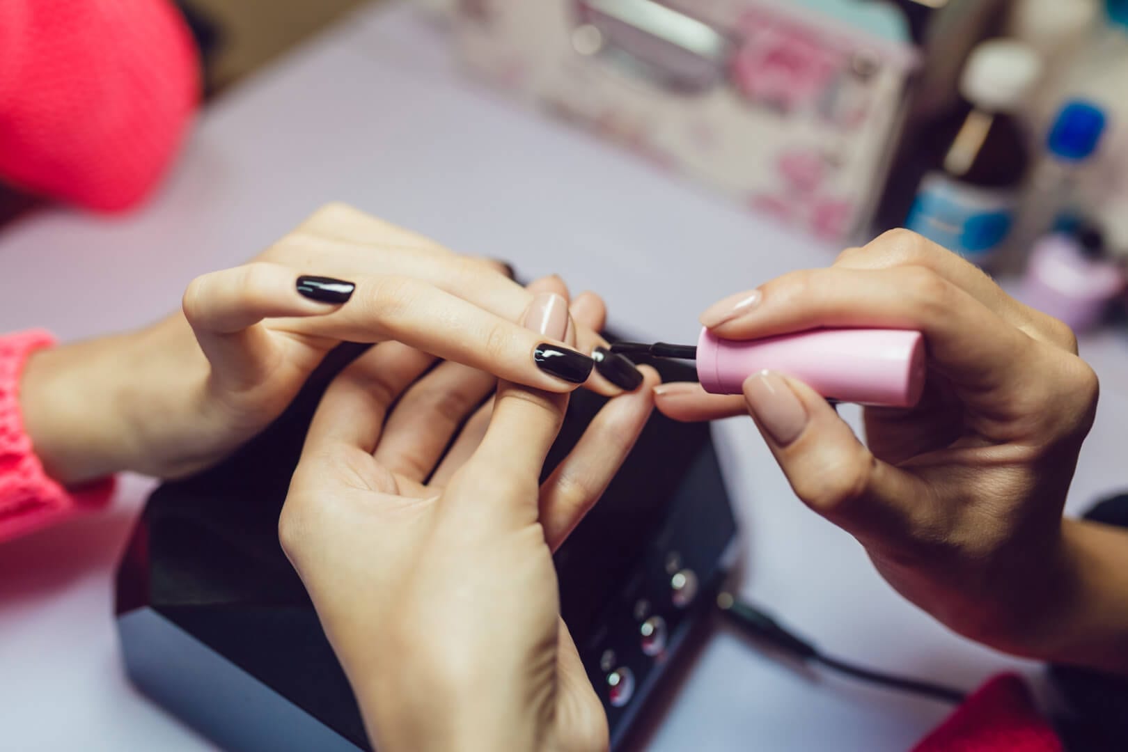 Manicure. Beauty salon. Close-up.Apply black nail polish.