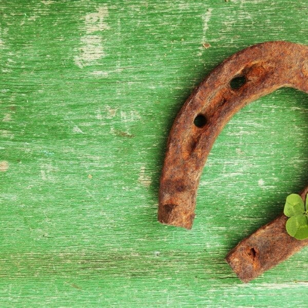 Old horse shoe,with clover leaf, on wooden background