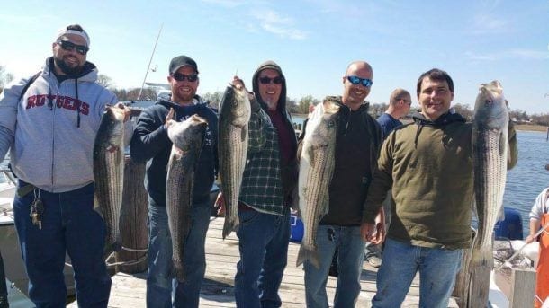 fishermen holding freshly caught fish