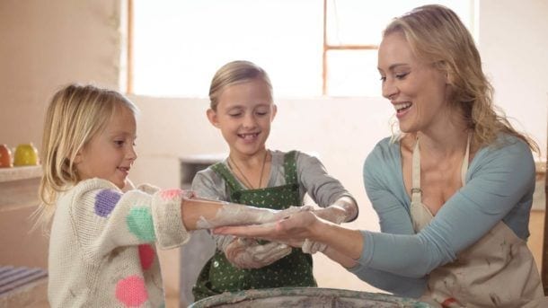 young girls making pottery with Mom