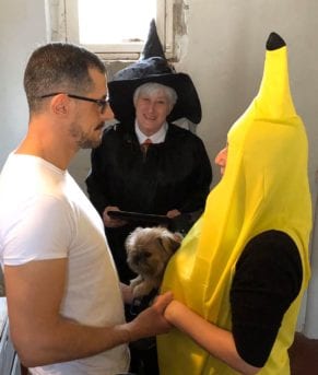 a man, a woman in a banana costume, and a witch officiant at a wedding