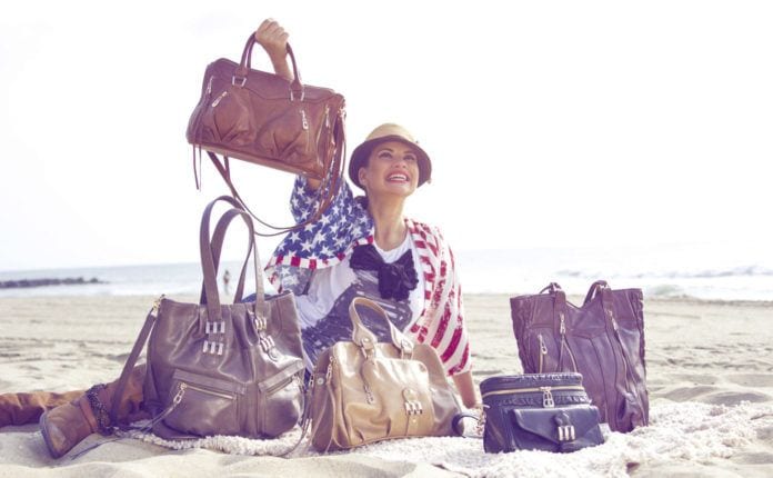 Photo of woman showing off handbags on the beach made by Crystal Kodada