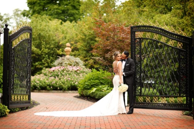 Newlyweds kissing by gate
