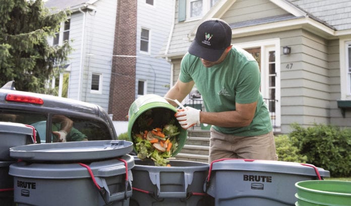 Man pouring compost into bin