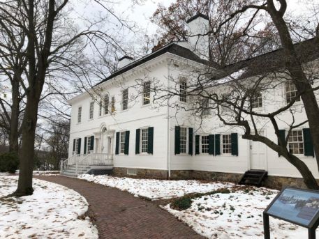 exterior show of white mansion in the snow