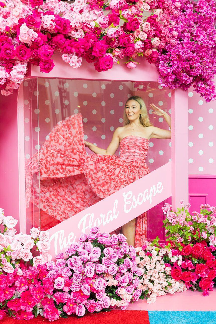 Woman posing inside floral themed photo booth