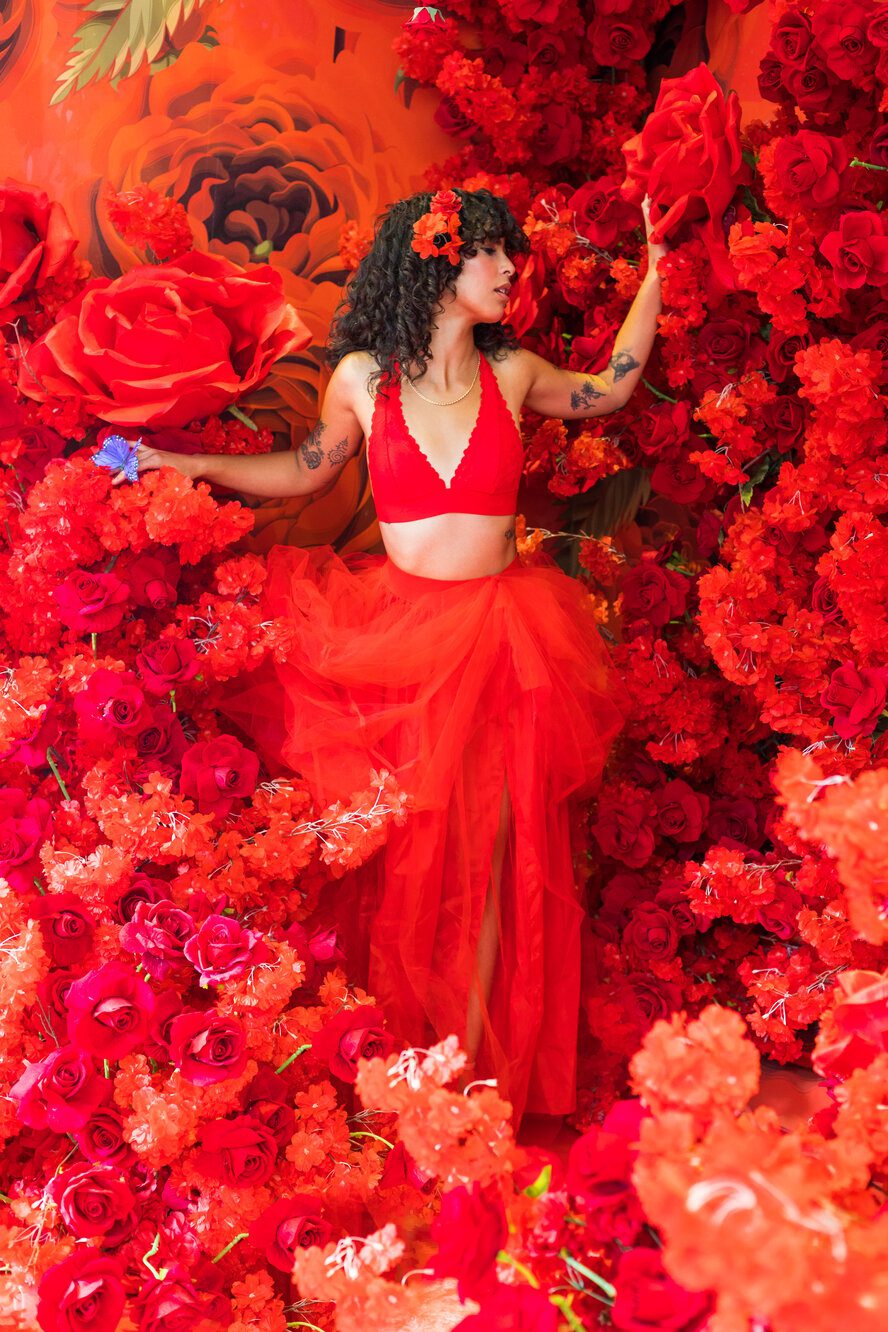 Woman posing surrounded by roses in bloom