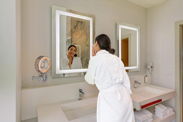 Woman looking in mirror of hotel bathroom