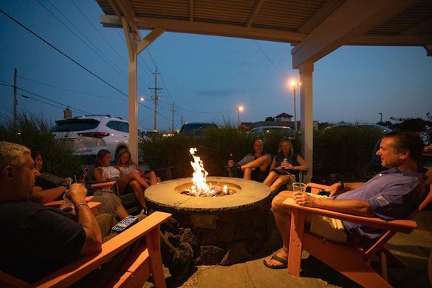 Guests Enjoying Food and Drinks by the Fire Pit at Mud City Crab House