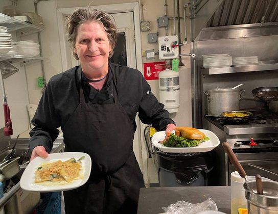 Chef Brian holding two dishes